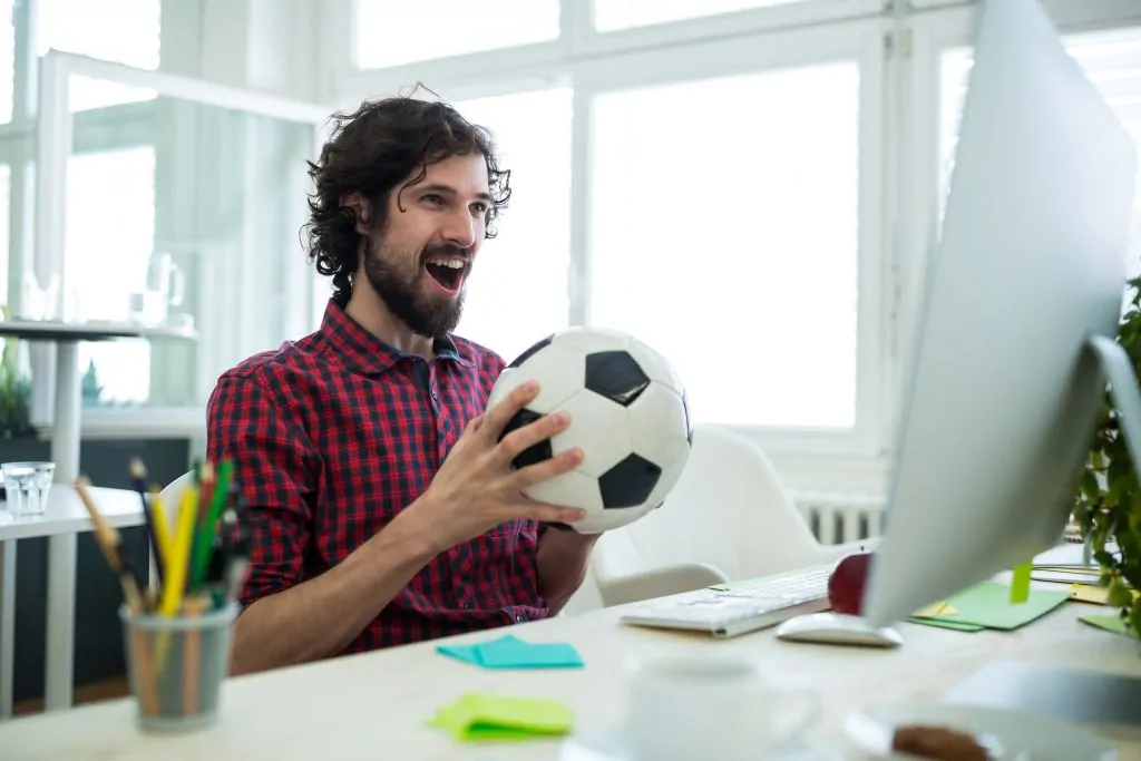 Businessexecutivewatchingafootballmatchoncomputer